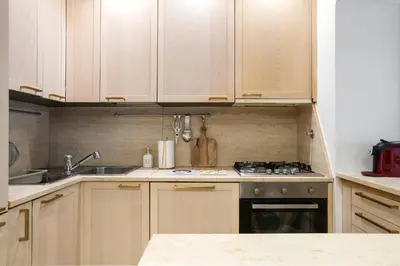 a kitchen with wooden cabinets and a stove top oven at Boschetto Boutique Apartment in Rome