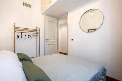a bedroom with a bed and a mirror on the wall at Boschetto Boutique Apartment in Rome
