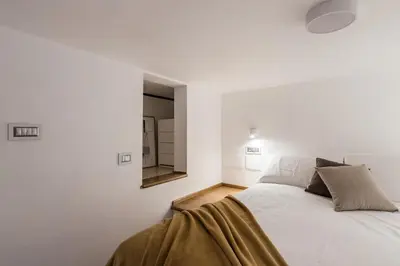 a white bedroom with a bed and a mirror at The Best Rent - One-bedroom flat in Tritone area in Rome