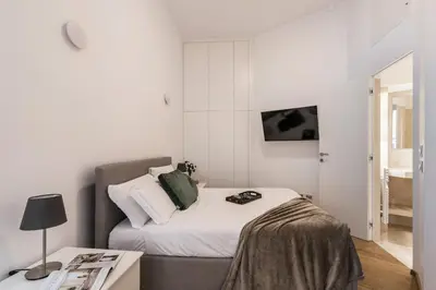 a small bedroom with a bed and a table at The Best Rent - One-bedroom flat in Tritone area in Rome