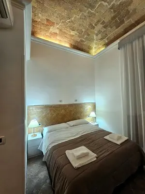 a bedroom with a large bed with two towels on it at Check in Rome in Rome