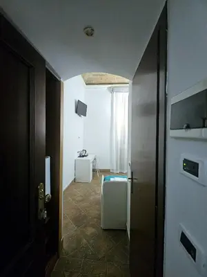 a hallway with a door to a room with a heater at Check in Rome in Rome