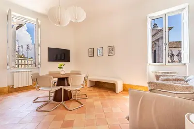 a living room with a table and chairs and windows at iFlat Vatican & Navona apartment with nice view in Rome