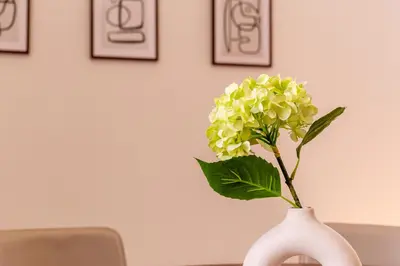 a white vase with a yellow flower in it at iFlat Vatican & Navona apartment with nice view in Rome