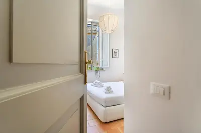 a door leading into a room with a bed and a mirror at iFlat Vatican & Navona apartment with nice view in Rome
