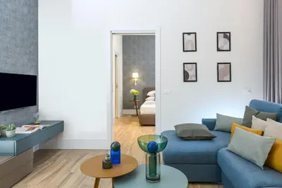 a living room with a blue couch and a tv at PO1 Augusto - PO2 Cesare - PO3 Nerone in Rome