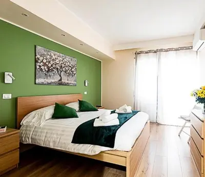 a bedroom with a large bed with a green wall at Dave's Home In Trastevere in Rome