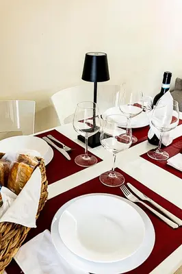 a table with white plates and wine glasses on it at Dave's Home In Trastevere in Rome