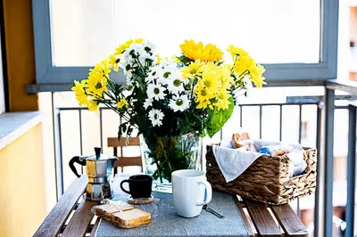a vase of yellow and white flowers on a table at Dave's Home In Trastevere in Rome