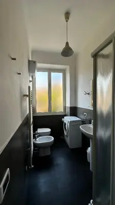 a bathroom with two sinks and a toilet and a window at ColleVaticano Roma in Rome