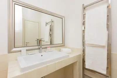 a white bathroom with a sink and a mirror at Amazing Ponte Milvio in Rome