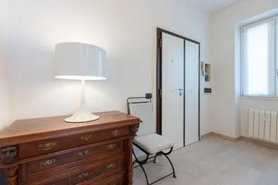 a bedroom with a dresser and a lamp and a chair at Amazing Ponte Milvio in Rome