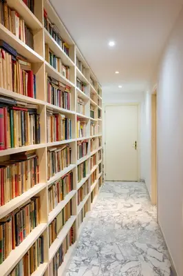 a hallway with bookshelves filled with books at Trieste Guesthouse - ZENO 48 in Rome