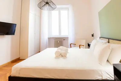 a bedroom with a white bed with towels on it at Trieste Guesthouse - ZENO 48 in Rome