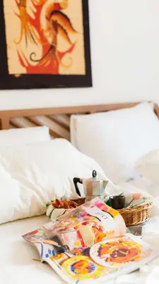 a tray of food and a basket on a bed at Trieste Guesthouse - ZENO 48 in Rome
