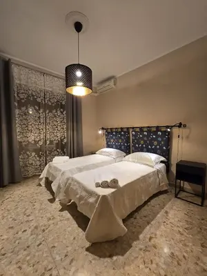 a bedroom with two beds and a pendant light at Al settimo cielo RomaPigneto in Rome