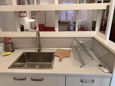 a kitchen counter with a sink and a mirror at Harmony Apartment Via Veneto in Rome
