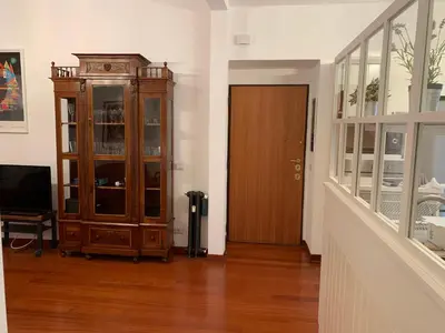 a living room with a wooden cabinet and a door at Harmony Apartment Via Veneto in Rome
