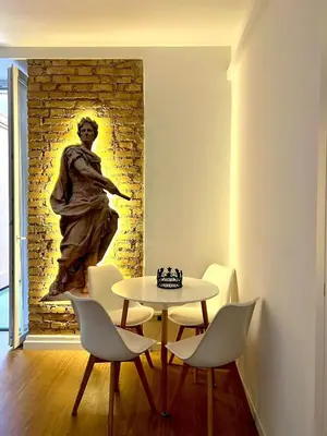 a table and chairs in a room with a statue at King's Place in Rome