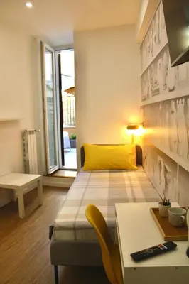 a small room with a bed and a desk with a computer at King's Place in Rome
