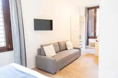 a living room with a couch and a flat screen tv at Relais Borsieri in Rome