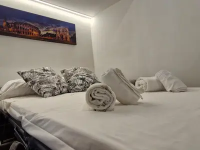 a bed with white sheets and pillows on it at Eternal City House in Rome