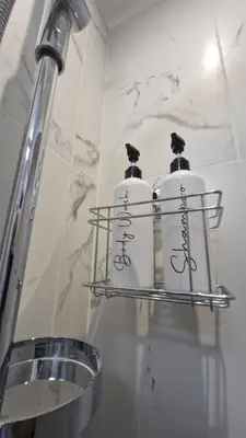 a shelf with three bottles on it in a bathroom at Eternal City House in Rome