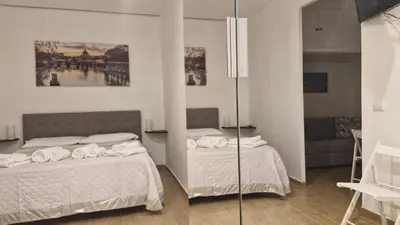 a bedroom with two beds and a mirror at Eternal City House in Rome