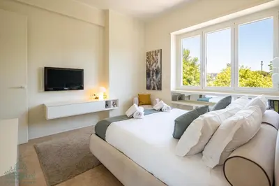 a bedroom with a white couch and a tv at Domus Consalvi - Ponte Milvio in Rome