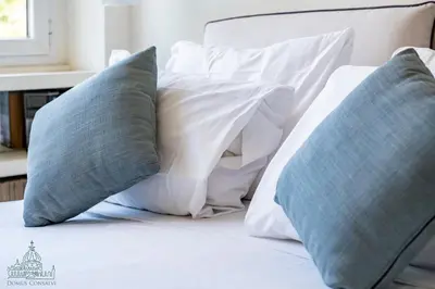 a bed with four pillows on top of it at Domus Consalvi - Ponte Milvio in Rome