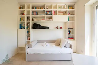 a room with a white couch in front of bookshelves at Domus Consalvi - Ponte Milvio in Rome