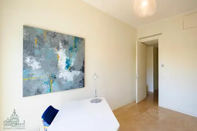 a white table in a room with a painting on the wall at Domus Consalvi - Ponte Milvio in Rome