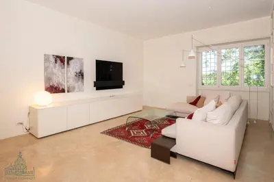 a white living room with a white couch and a tv at Domus Consalvi - Ponte Milvio in Rome