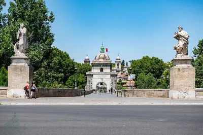 a bridge with a building in the background with a statue at Domus Consalvi - Ponte Milvio in Rome