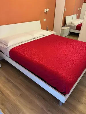 a bed with a red blanket on top of it at Caos Calmo House in Rome