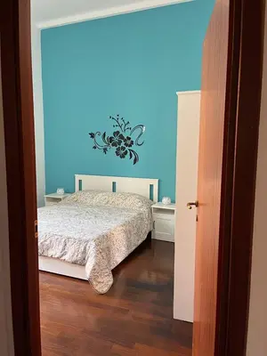 a bedroom with a bed and a blue wall at Casa a San Giovanni - Charming Flat in Rome in Rome