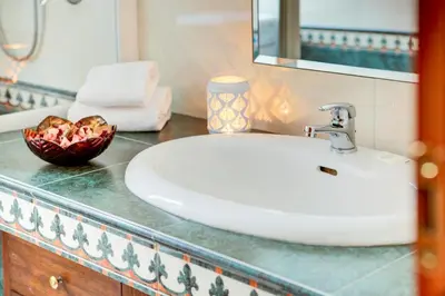 a bathroom sink with a bowl of fruit on a counter at Casa a San Giovanni - Charming Flat in Rome in Rome