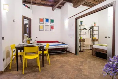 a dining room with a table and chairs and a bed at Cacio e Pepe FLATS 1 & 2 in Rome