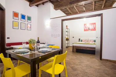 a dining room with a table and yellow chairs at Cacio e Pepe FLATS 1 & 2 in Rome