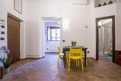 a dining room with a table and yellow chairs at Cacio e Pepe FLATS 1 & 2 in Rome