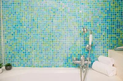 a blue tiled bathroom with a tub and a shower at Cacio e Pepe FLATS 1 & 2 in Rome