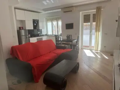 a living room with a red couch and a kitchen at 4venti house in Rome