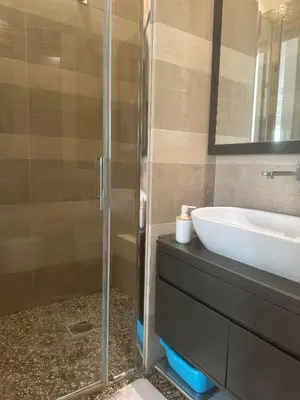 a bathroom with a glass shower and a sink at 4venti house in Rome