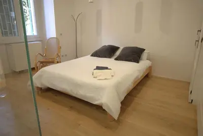 a small kitchen with white cabinets and a wooden floor at La Casetta in Rome