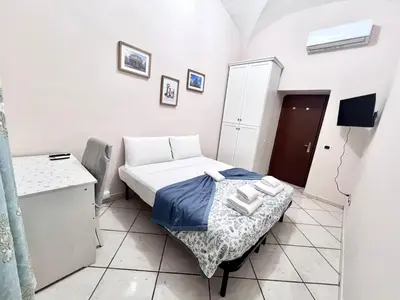 a small room with a bed and a table at Rome Is Home in Rome