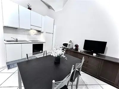 a kitchen with a table with chairs and a tv at Rome Is Home in Rome