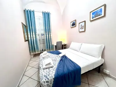 a bedroom with a white bed with blue sheets at Rome Is Home in Rome