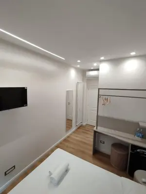 a white room with a bed and a flat screen tv at Charlie Up! in Rome