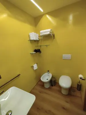 a yellow bathroom with a toilet and a sink at Charlie Up! in Rome
