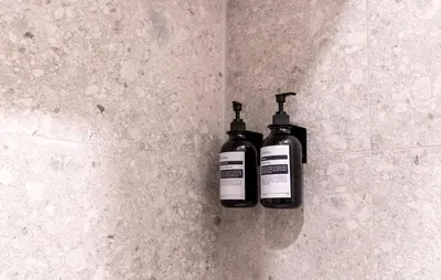 two bottles ofodorizers sitting on a tile wall at Cunabu Urbano V in Rome
